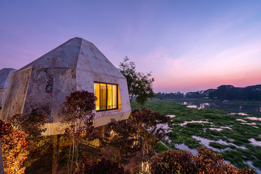 A dome-shaped building beside rice fields at dusk at THANN Wellness Destination, Ayutthaya